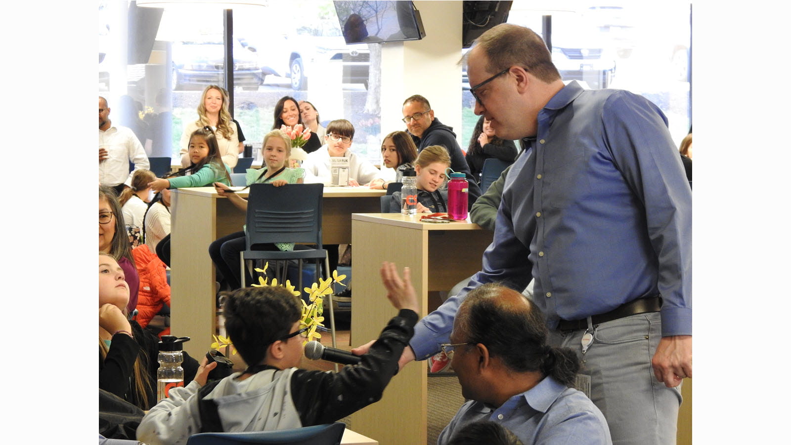 A young visitor speaks into a microphone during a Q&A during Take Our Daughters and Sons to Work Day.